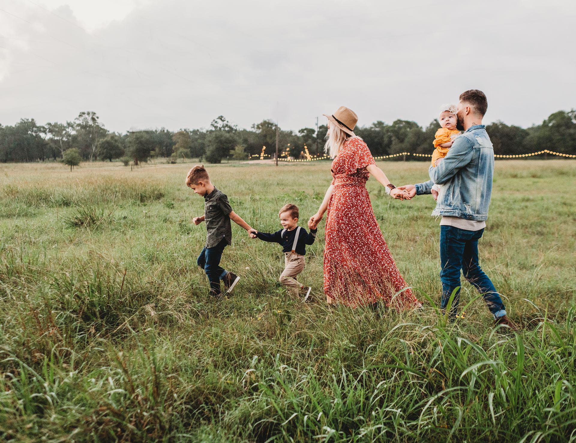 a group of people standing on top of a grass covered field